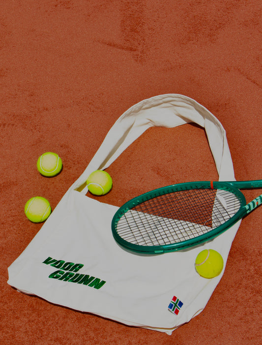 Voor Grunn Totebag op een tennisbaan met een tennisracket en tennisballen